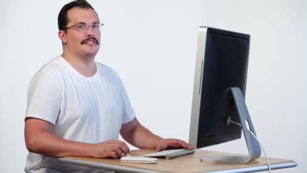 Чоловік дивиться на монітор комп'ютера і сміється — стокове відео