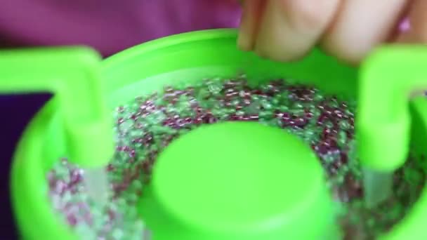 Girl hands assembles colorful beads — Stock Video