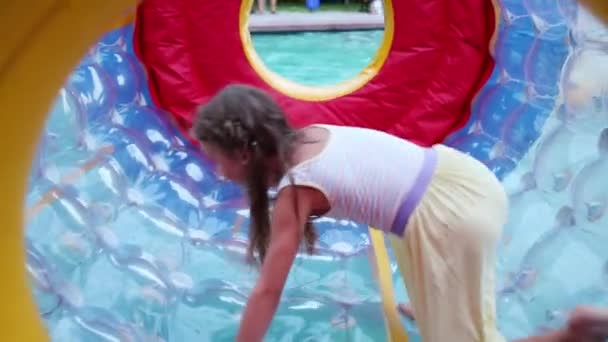 Girl runs in big inflatable cylinder on water — Stock Video