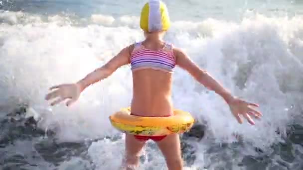 Fille avec anneau gonflable dans les vagues de la mer — Video