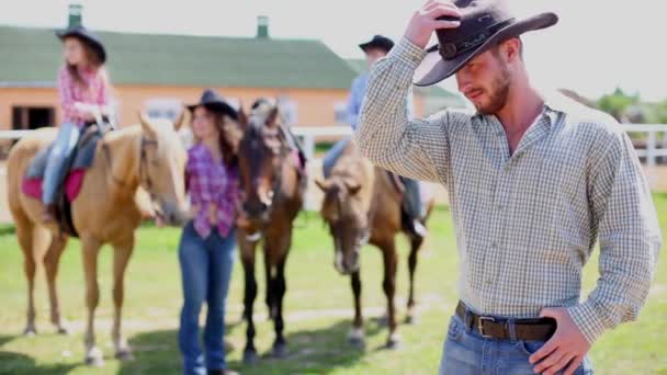 Man stands foreground, looks back to his family — Stock Video