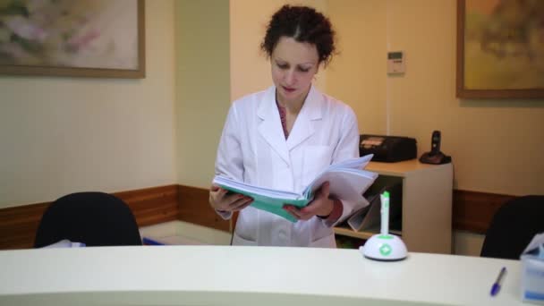 Doctor looks through folder with documents — Stock Video