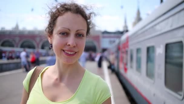 Mujer joven se para cerca del tren — Vídeo de stock