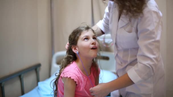 Médecin attache des fils aux oreilles de la fille — Video