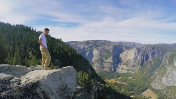 Tourist steht auf Felsen in Waldnähe — Stockvideo