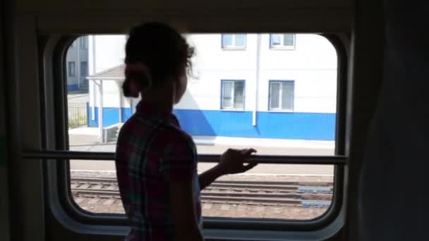 Dziewczyna, patrząc w okno w nowoczesny pociąg. — Wideo stockowe