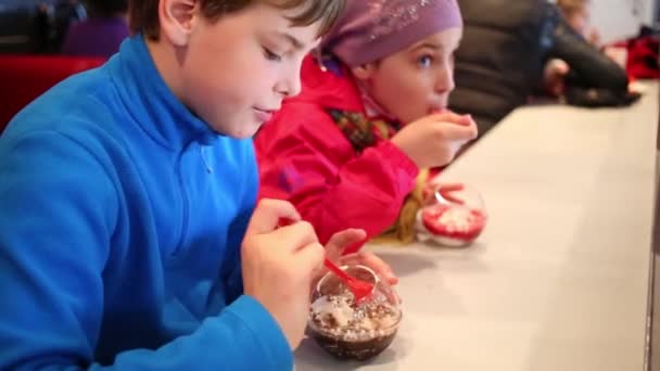 Девочка и мальчик едят мороженое — стоковое видео