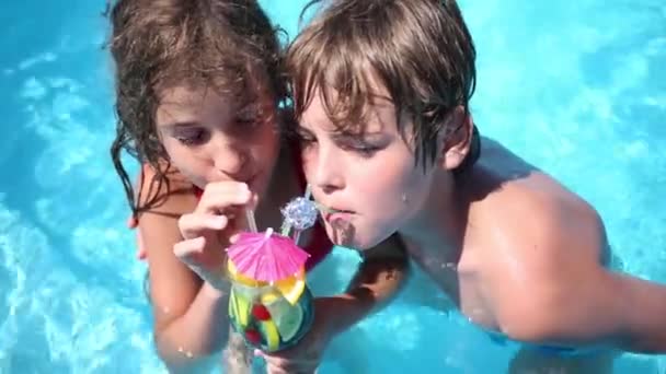 Мальчик и девочка пьют тропический коктейль — стоковое видео