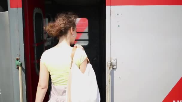 Mujer joven entra en tren — Vídeo de stock