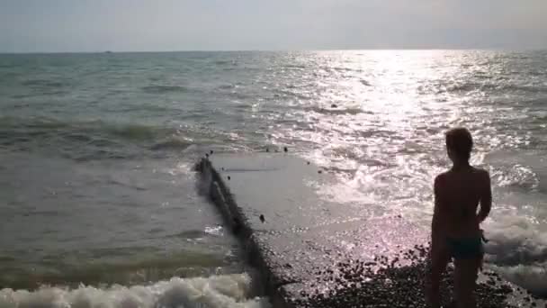 Woman in swimsuit walks on concrete pier — Stock Video