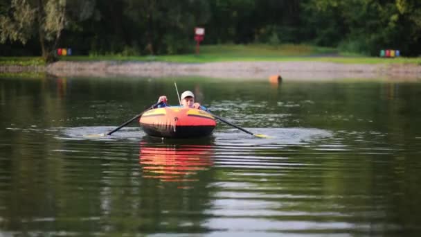 Boy paddles in inflatable boat — Stock Video