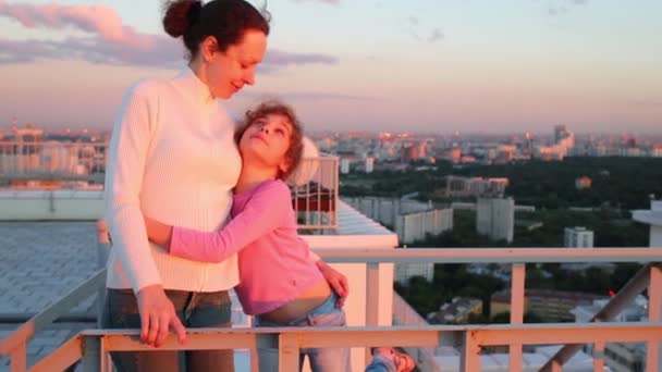 Mother and daughter hugging on roof — Stock Video