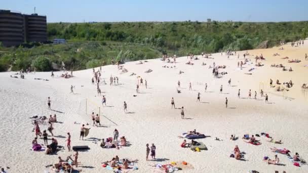 Люди отдыхают на пляже и купаются в воде — стоковое видео