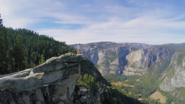 Turista stojí na vrcholu rocky mountain — Stock video