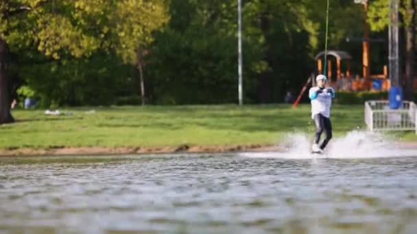 Hombre wakeboarder salta y gira a bordo — Vídeos de Stock