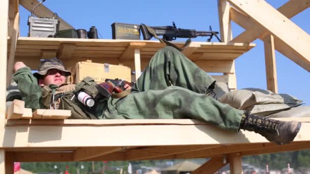 Homme en uniforme couché sur une construction en bois — Video