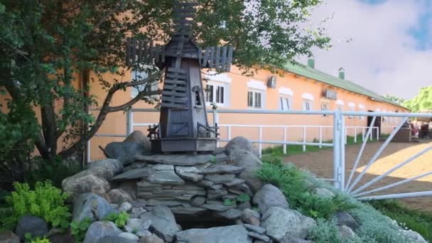 Modelo de madera de un molino de viento, montado en una colina de piedra — Vídeos de Stock