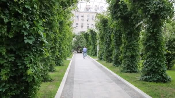 Człowiek na rowerze w bluszcz korytarza odkryty park — Wideo stockowe