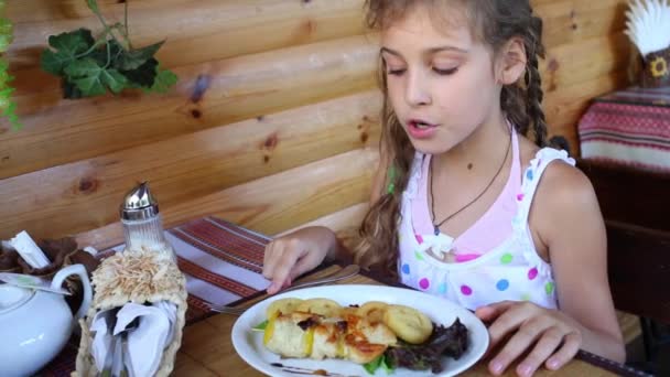 Niña mira la comida y habla — Vídeos de Stock