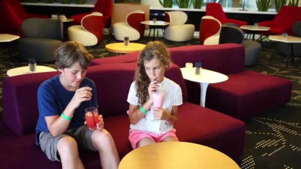 Мальчик и девочка пьют коктейли — стоковое видео