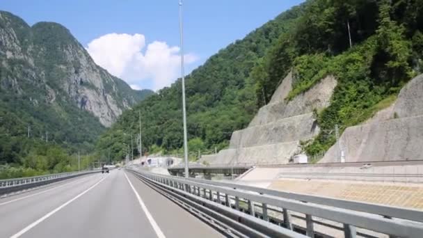 Rörelse på vägen nära järnvägen bland bergen — Stockvideo