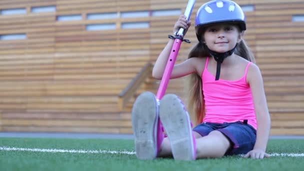 Девушка в шлеме сидит со скутером — стоковое видео