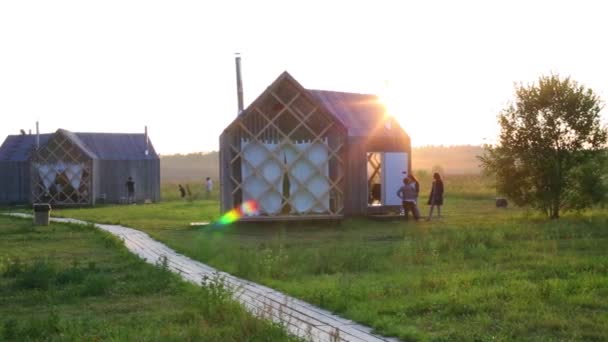 Sol e pessoas perto de pequenas casas na aldeia — Vídeo de Stock