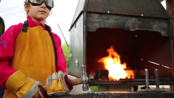 Mädchen mit Hammer steht neben Ofen — Stockvideo