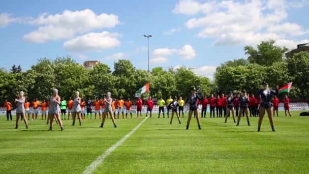 Bailarines y equipos de fútbol en el campo — Vídeo de stock