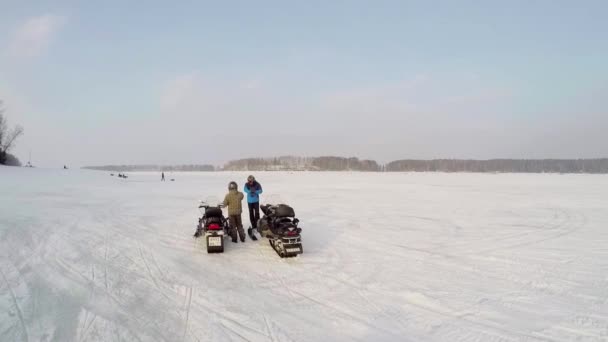 Δύο άνδρες στέκονται κοντά snowmobiles — Αρχείο Βίντεο