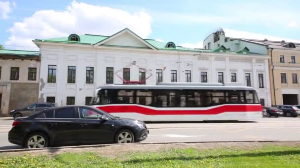 Tram moves on street and cars are parking — Stock Video