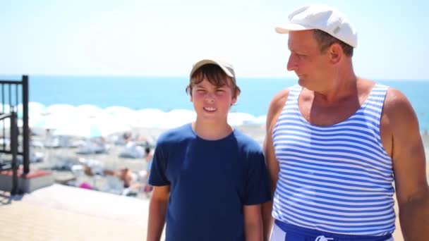 Uomo e ragazzo parlano vicino al mare — Video Stock