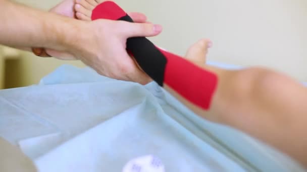 Руки врача приклеили скотчем на ноги ребенка — стоковое видео