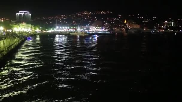 Vista nocturna del mar, montaña, terraplén y personas — Vídeo de stock