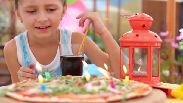 Niña sopla velas en la pizza — Vídeos de Stock