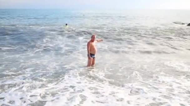 Homem fica perto da costa no mar — Vídeo de Stock