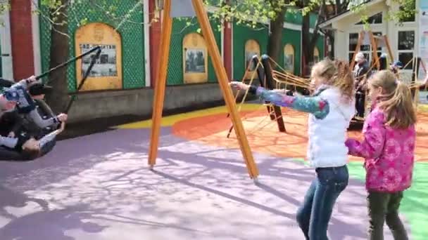 Meisjes swingende wankelen bord met jongens — Stockvideo