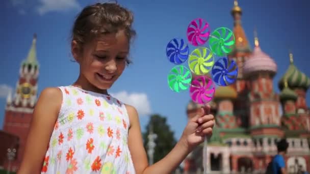 Menina sorridente com pinwheel na Praça Vermelha — Vídeo de Stock