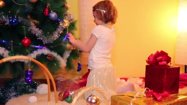Kleines Mädchen schmückt Weihnachtsbaum — Stockvideo