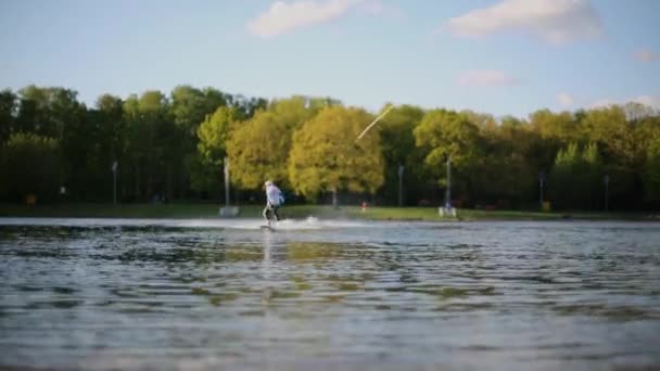 Hombre wakeboarder deslizándose sobre el agua en el estanque — Vídeos de Stock