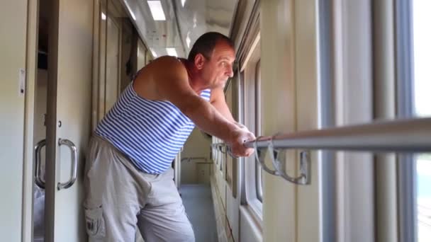 Пожилой человек смотрит на окно в поезде — стоковое видео