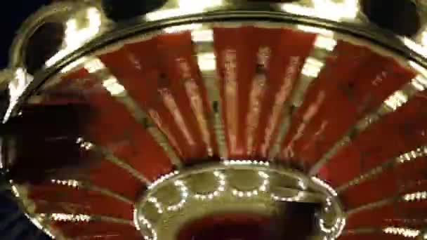 Happy children ride on carousel at night — Stock Video