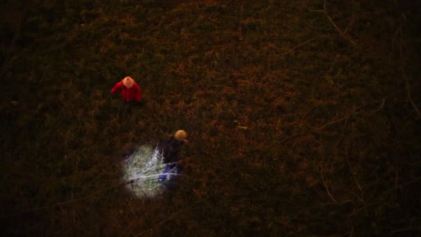 Niña y niño corriendo con la luz cuadrada en la hierba por la noche — Vídeos de Stock