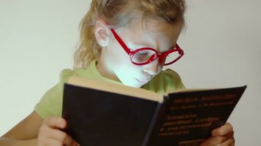 Küçük kız kitap tutar