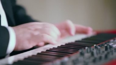 Takım elbiseli adam dijital piyano çalıyor