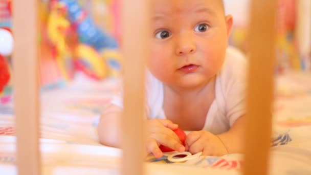 Le gamin repose sur un lit bébé — Video