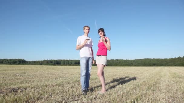 Парень с девушкой стоит в поле — стоковое видео