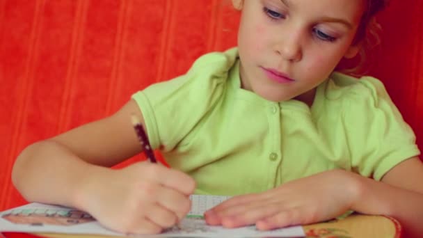 Маленька дівчинка малює на папері — стокове відео