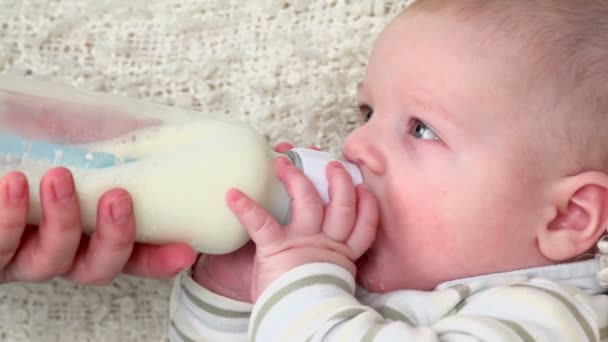 小さな男の子の赤ちゃんはミルクを飲む — ストック動画