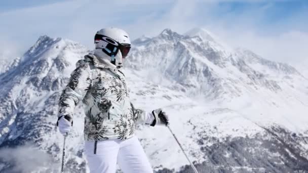 Vrouw skiër staat op de top van de heuvel — Stockvideo